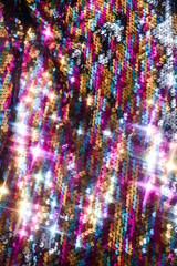 Sequins close-up macro. Abstract background with sequins colorful on the fabric. Texture scales of round sequins 