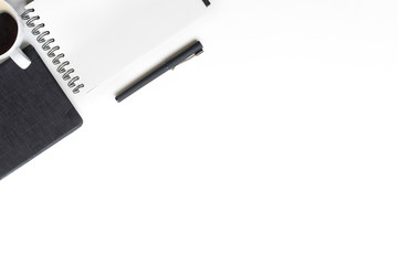 Office desk with notebook paper, pen and coffee cup top view workspace.