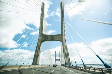 Peel and stick wall murals Unusual or original view of the Vasco da Gamma Bridge in Lisbon in Portugal. The bridge is moving vehicles or cars.