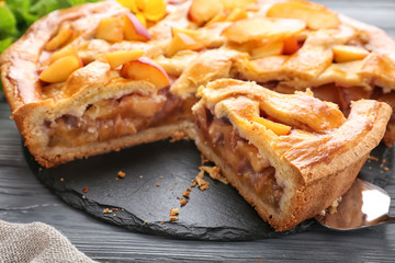 Tasty homemade peach pie on wooden table, closeup