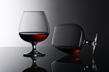 Two snifters of brandy on glass table