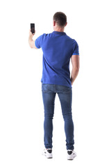 Rear view of modern adult casual man taking photo with smart phone. Full body isolated on white background. 