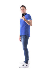 Side view of adult casual man taking photo and holding mobile phone. Full body isolated on white background. 