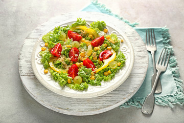Plate with healthy fresh salad on wooden board