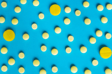 Different pills on the blue background, health care concept.