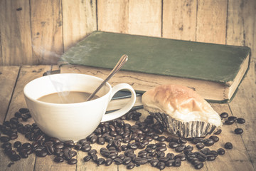 Coffee cup and coffee beans on old wooden background