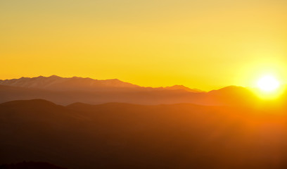 sunset in the mountains, backlight, the sun hides behind the mountains, an observation deck, the rays of the sun, the end of the day