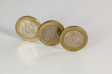 Euro coins on white background with reflections