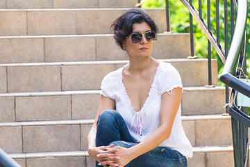 A middle-aged woman is sitting on the steps