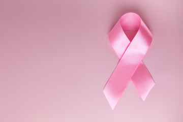 Pink ribbon on pink background as symbol of female breast disease. Breast cancer month awareness tape. Minimalistic style. Top view. Flet lei. Place for text. Copy space. © tumana_net