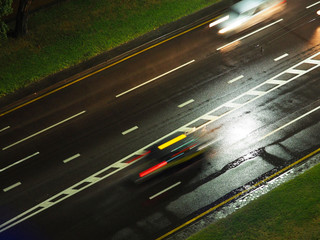 Highway road at night in the rain in the light of street lamps. Top view, motion blur