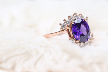 Purple gem stone on gold ring