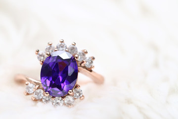 Purple gem stone on gold ring