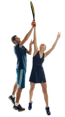 Woman practicing a serve shot with a handsome trainer. Learning and playing tennis. Education concept.