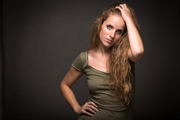 Fototapeta premium Studio glamour portrait of a pretty, young woman with lovely curly hair