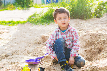 boy playing in the sand in summer