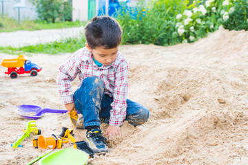 boy playing in the sand in summer