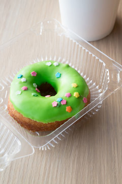 Disposable coffee cup with fresh donut