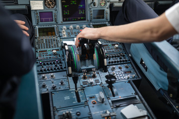 Fototapeta na wymiar Pilot's hand accelerating on the throttle in a commercial airliner airplane flight cockpit during takeoff