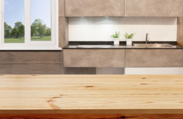 Wood table top on blur kitchen window background, banner - can be used for montage your products or foods