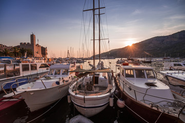 Beautiful sunset sun by the Adriatic sea with boats and sailing yachts travel in summer, Komiza harbor port, Vis island, Croatia
