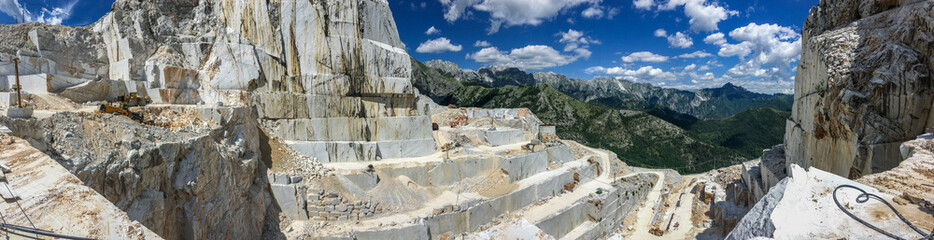 Naklejka premium Wysokie kamienne góry i kamieniołomy marmuru w Apeninach w Toskanii, Carrara we Włoszech. Odkrywkowe wydobycie marmuru.