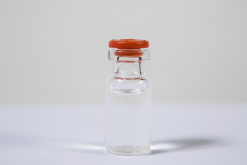 Group of vials with medication on blue methacrylate table.