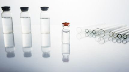 Group of vials with medication on blue methacrylate table.