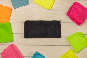 Colorful, dry microfiber wipes for different surfaces, cleaning the house. Empty space for text or logo on light wooden background. The concept of cleaning. Regular cleaning.