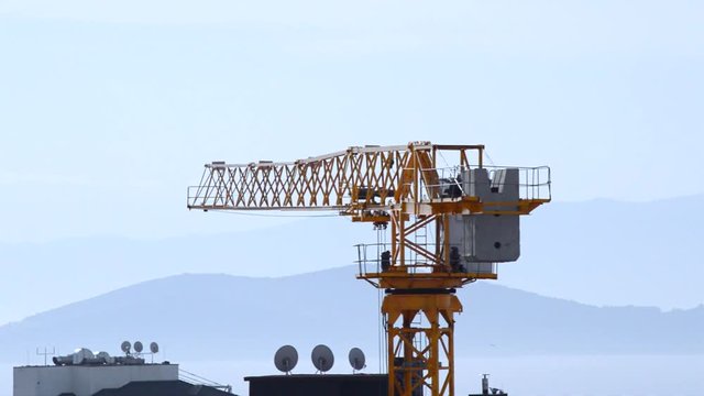 Close up of tower crane swinging slowly with wind in Kadikoy, Istanbul, Turkey 