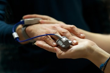 Obraz na płótnie Canvas Close up of nurse a patients pulse using a pulse oximeter