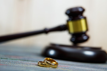 Closeup of wedding rings on wooden mallet at table