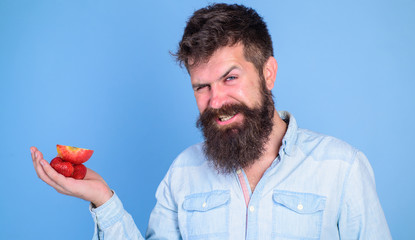 I have treats for you. Man offers to try strawberries and apple fruit treats blue background....