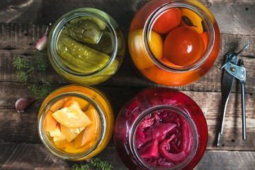 Jars of pickled fresh, homemade vegetables on a wooden background. Top view. Autumn concept. Stock of food