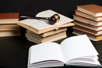 Judge gavel beside pile of books on wooden background