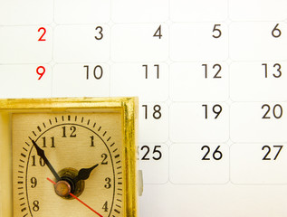 Grunge old clock over white calendar.