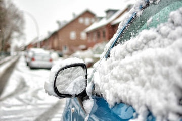 Houses, cars and streets are covered with snow. Winter.