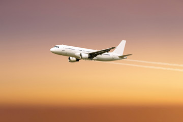 Fototapeta na wymiar Airplane flying over sunset background