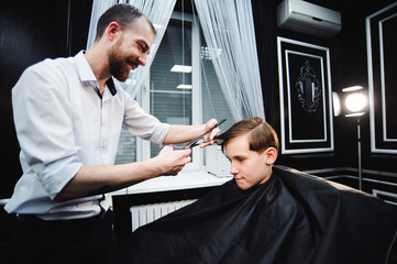 Fototapeta premium cute young boy getting a haircut