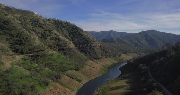 drone shot/ helicopter shot of a river inside the mountains.