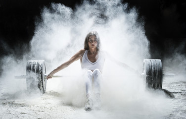 Fototapeta premium Woman working out with weights in the gym