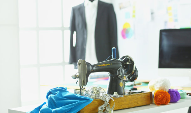 Retro sewing machine on designer clothes desktop