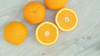 Oranges fruit in a basket on a wooden table.