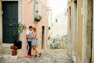 Young couple hugging each other in the street of Lisbon, Portugal. Romantic relationships concept