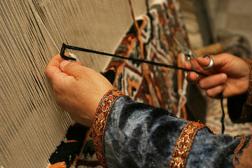 a diligent woman makes a traditional carpet by hand, oriental ornament, Tunisia