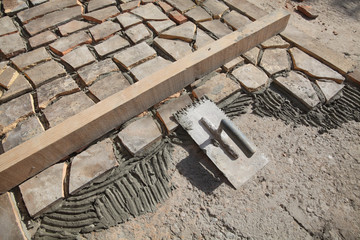 Old tiles recycling, making terrace or pavement using tile pieces, mortar and tile adhesive with trowel tool