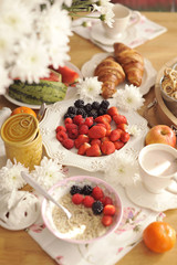 A large bouquet of white flowers on the table and breakfast for the family. Cozy house and delicious food. Seasonal Fruits, pastries and fragrant coffee. Copy space,