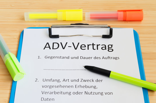 klemmbrett mit einem Vertrag und Aufschrift in deutsch ADV-Vertrag in english ADV-Vertrag und Gegenstand und Dauer des Auftrags und Umfang Art und Zweck der vorgesehenen Erhebung
