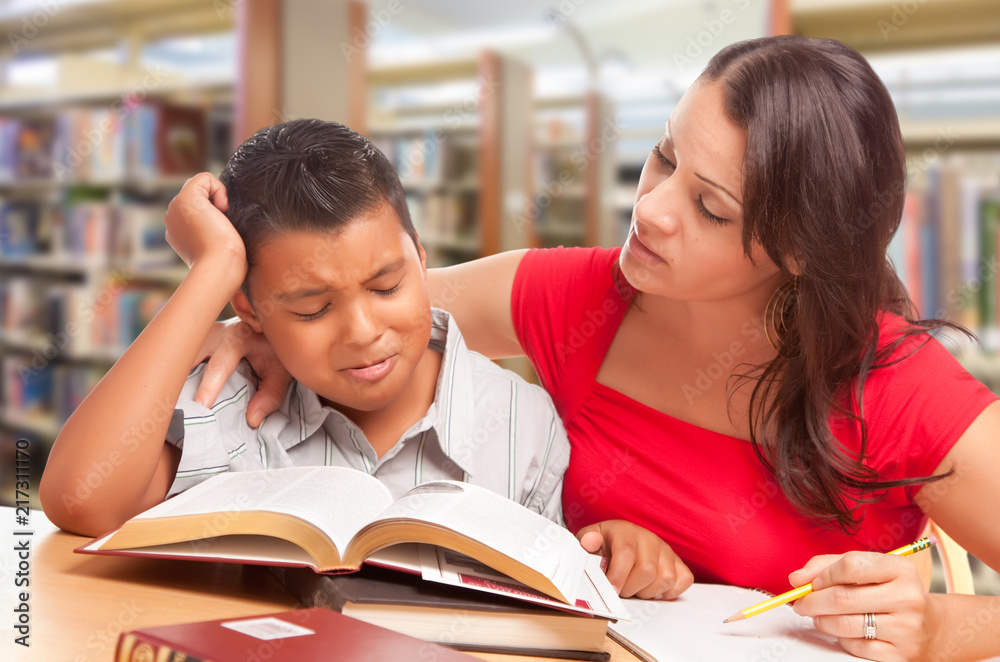 Wall mural Upset Hispanic Young Boy and Famle Adult Studying At Library