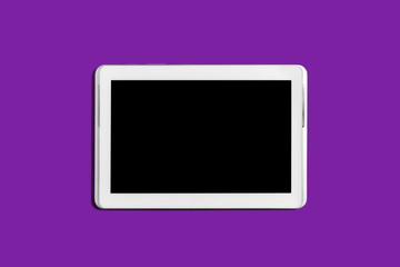 new modern white tablet pc lying on a purple background with a turned off screen. concept of gadgets